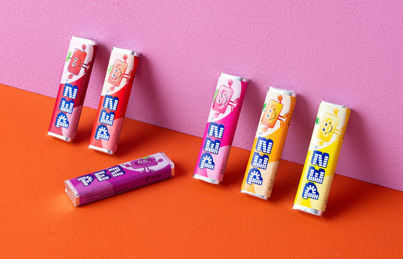 PEZ Bonbons in verschiedenen Geschmacksrichtungen auf pink-rotem Hintergrund