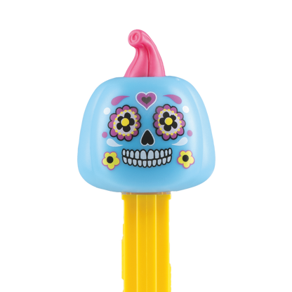 Detailansicht des PEZ-Spenders 'Día de los Muertos': Ein hellblauer Kürbis mit pinkem Stiel, verziert mit kunstvollen Totenkopf-Bemalungen, bunten Blumen um die Augen und einem gelben Spenderkörper.