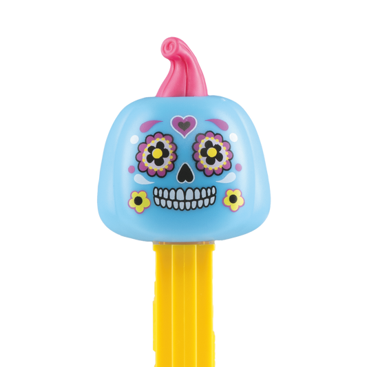 Detailansicht des PEZ-Spenders 'Día de los Muertos': Ein hellblauer Kürbis mit pinkem Stiel, verziert mit kunstvollen Totenkopf-Bemalungen, bunten Blumen um die Augen und einem gelben Spenderkörper.