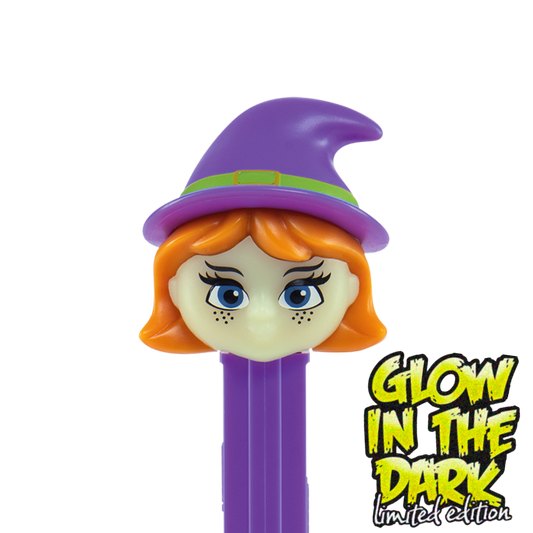 Detailansicht des PEZ-Spenders 'Hexe Glow in the Dark': Ein Hexenkopf mit violettem Spitzhut, orangefarbenen Haaren, blauen Augen und Sommersprossen auf einem violetten Spenderkörper.