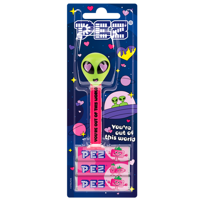 PEZ-Spender mit grünem Alien Kopf und rosa Herzaugen. Das Spendergehäuse ist pink mit schwarzer Aufschrift "You're out of this world".